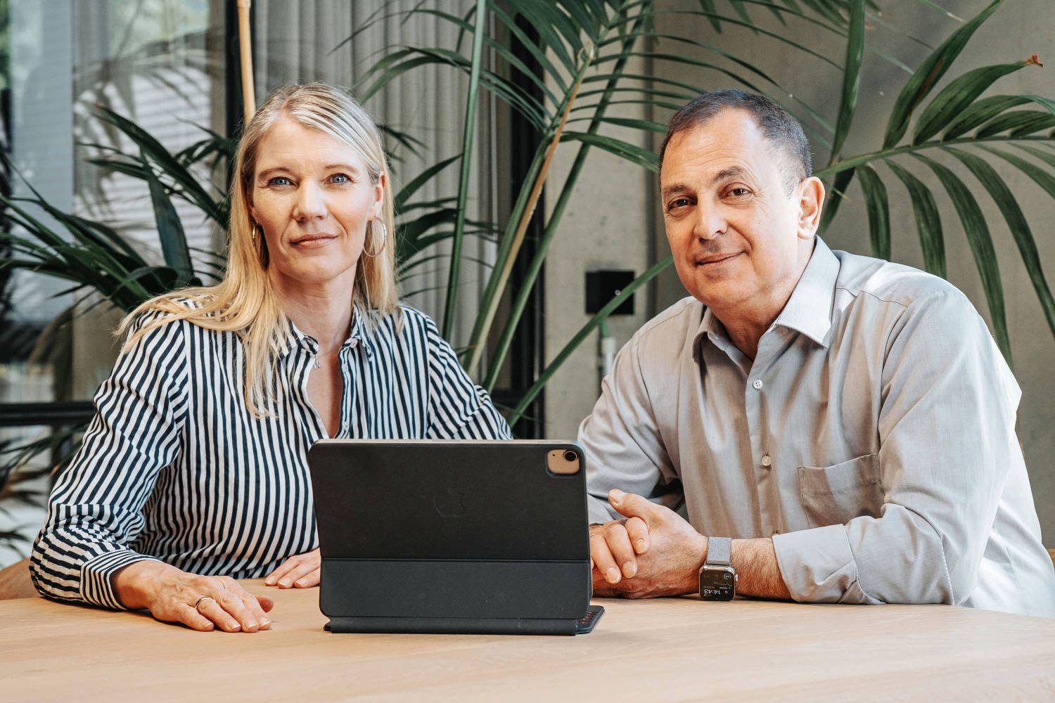 kzenta Immobilien Mitarbeiterin und Mitarbeiter im Gespräch am Tisch mit Laptop – Experten für Erbschaftsimmobilien